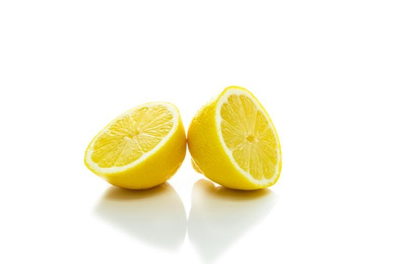 Sitruuna, joka on halkaistu kahtia valkoisella taustalla. 